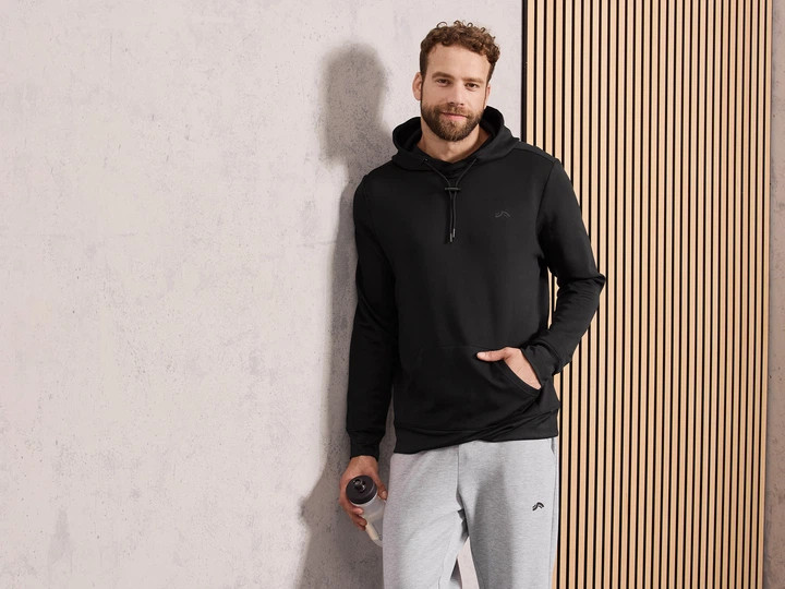 خرید هودی مردانه Crivit مشکی با پارچه تریکوی ضخیم و جیب کانگرو، کلاه با بند قابل تنظیم، مناسب استفاده روزمره و ورزش سبک نمای تنخور | صبامی